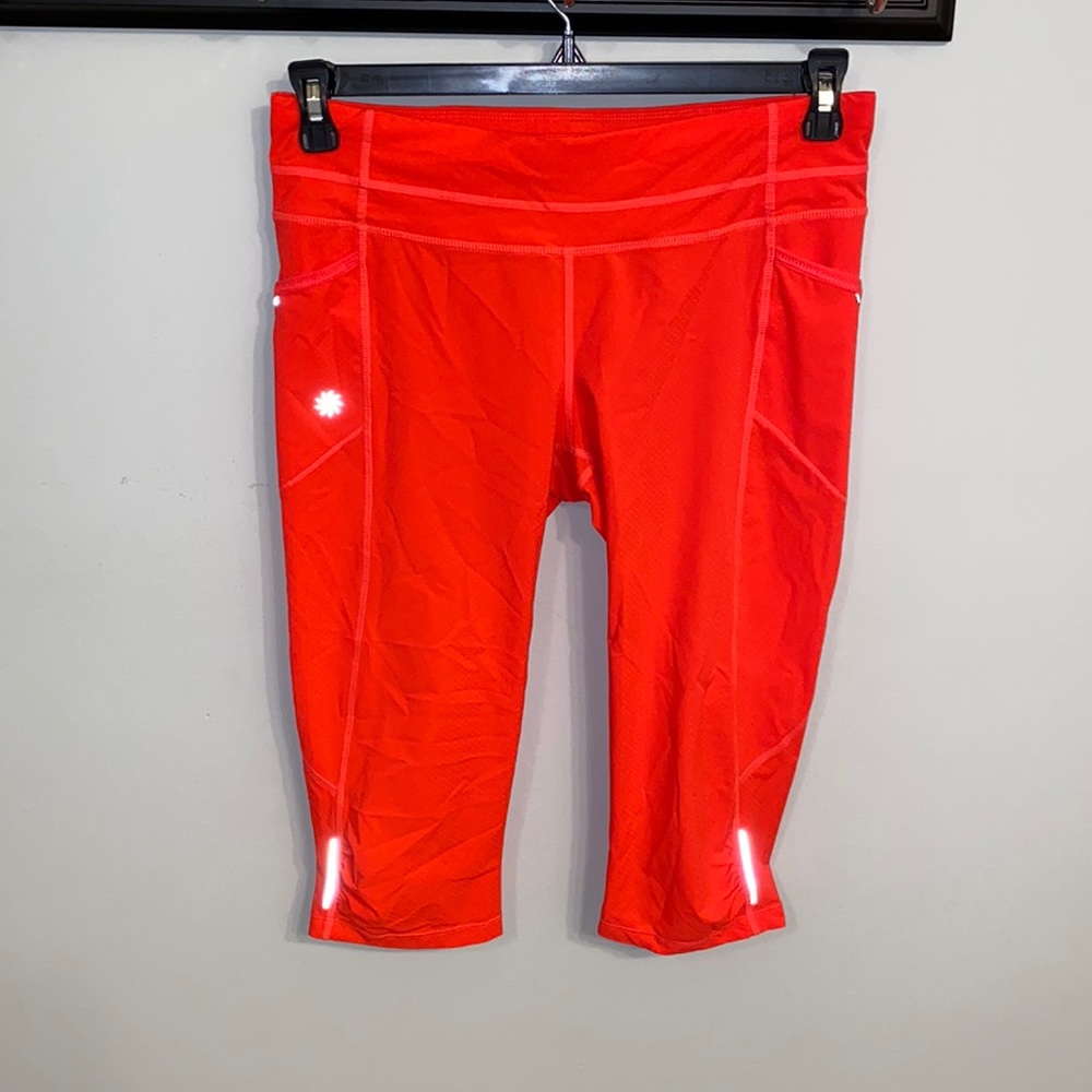 Athleta NWOT orange, thin leggings with side pockets, zip packet size Medium